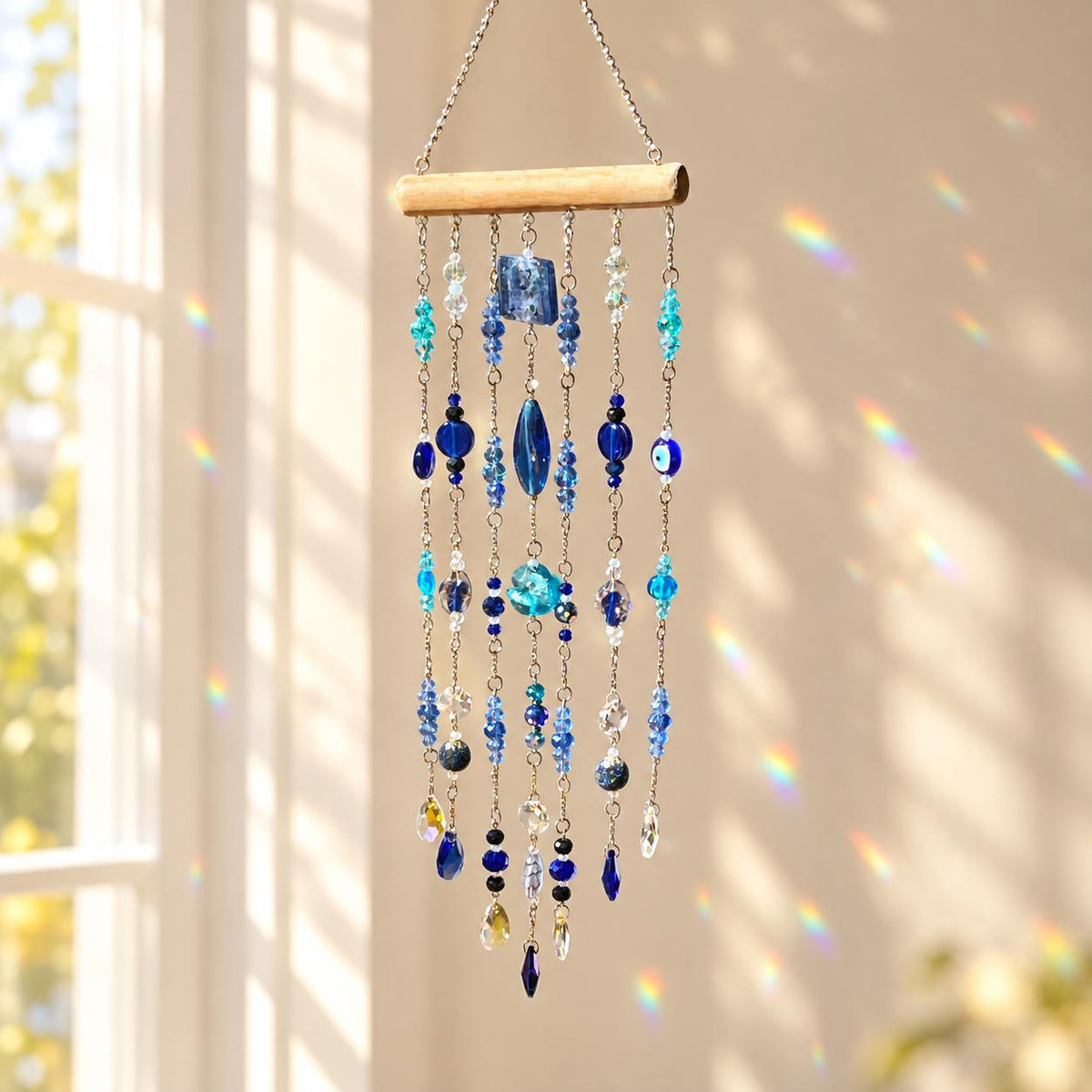 Blue and turquoise window suncatcher with faceted beads, deep blue glass accents, sparkling crystals and an evil eye bead.